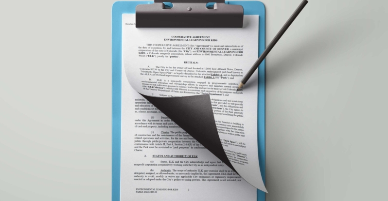 A clipboard showing the City of Denver's Cooperative Agreement